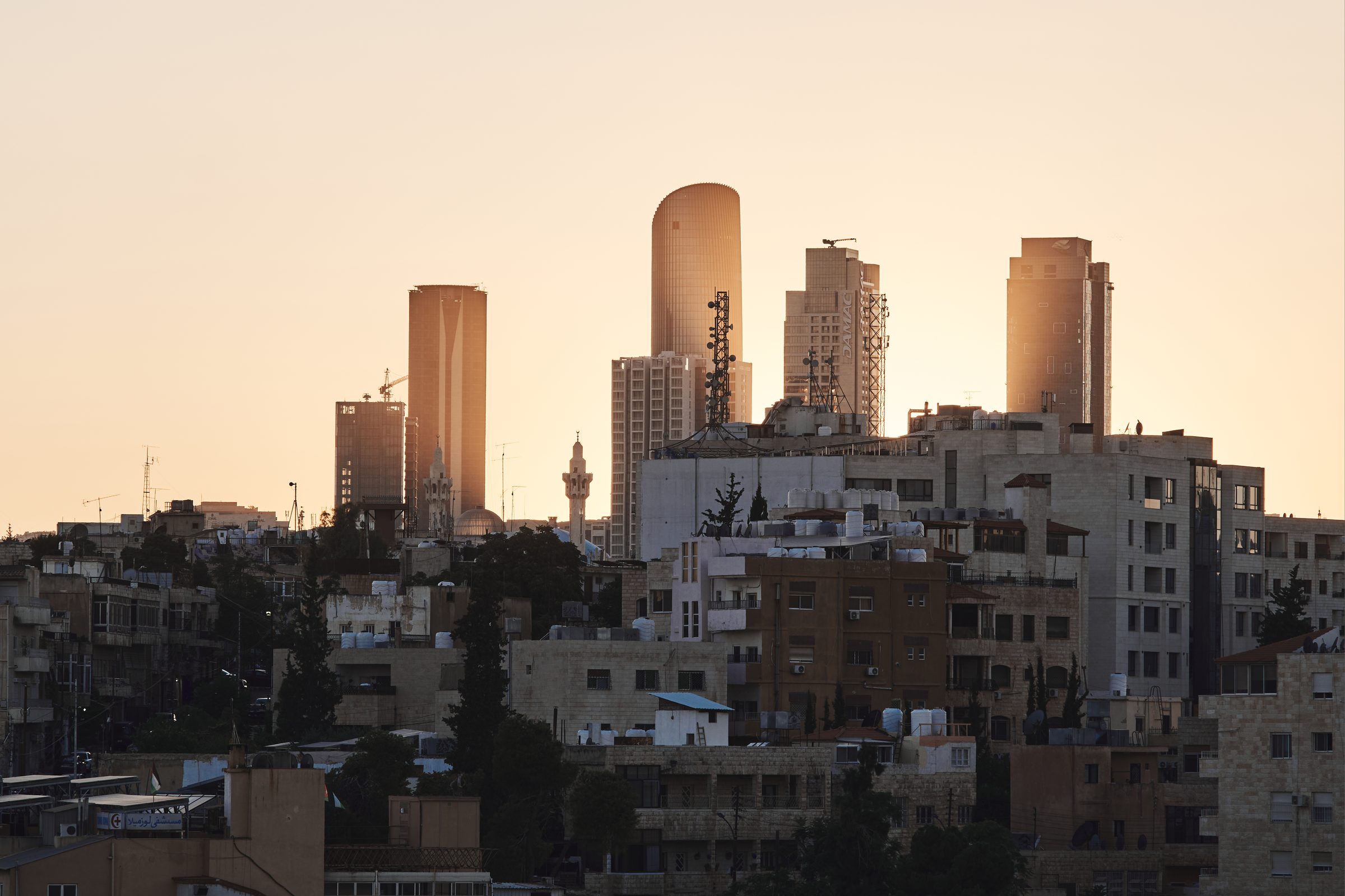 Modern towers above older buildings in warm light