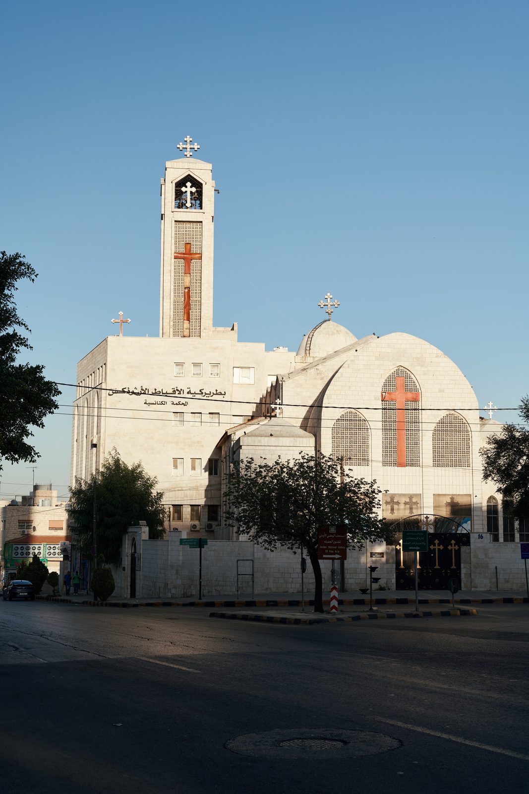 White church with a bell tower at the end of a quiet street