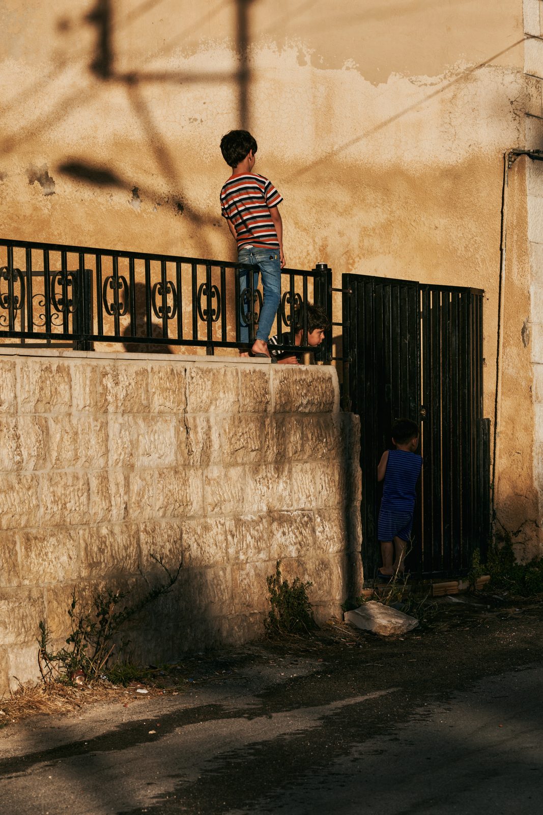Boy standing on top of a wall