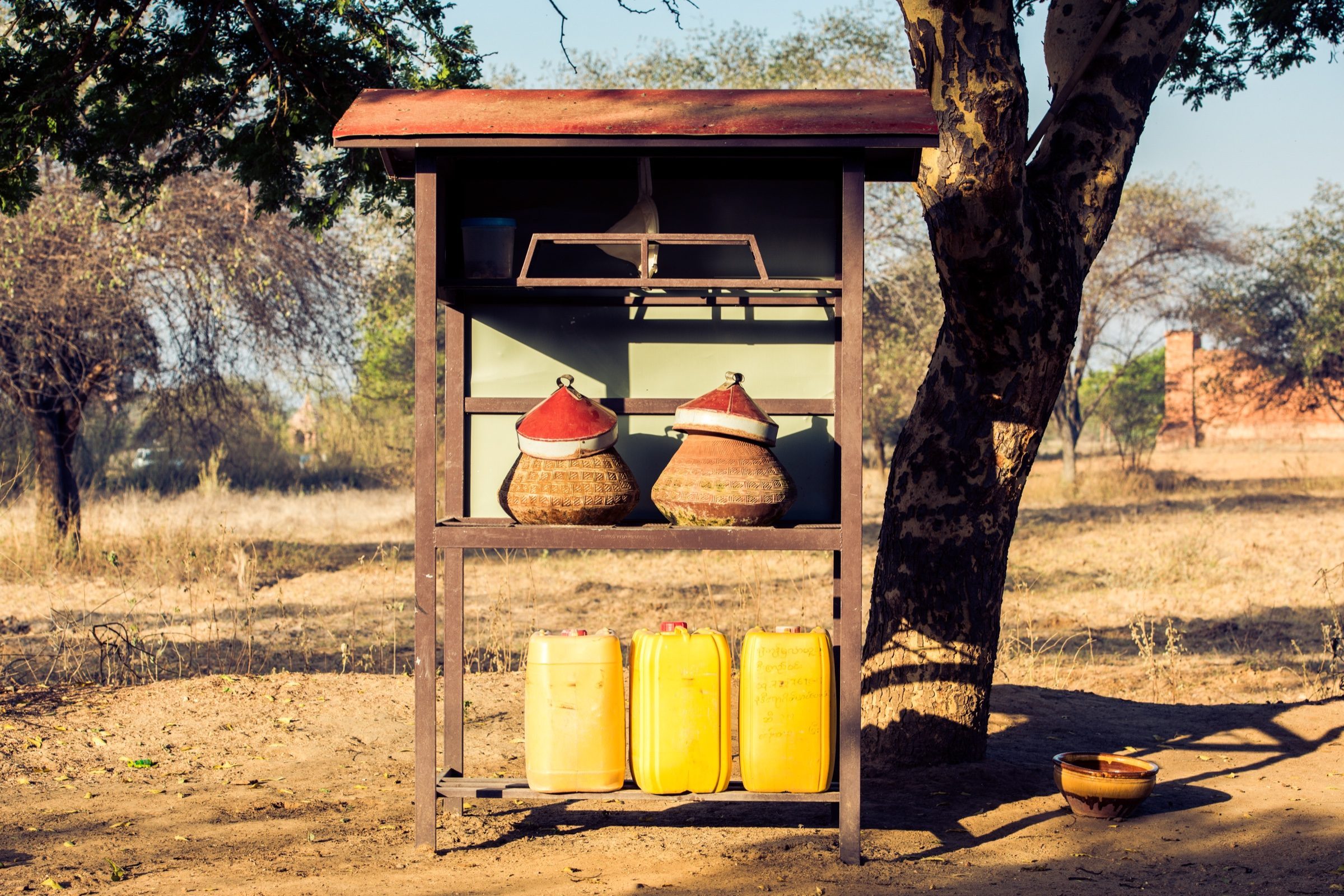 A roadside water stand with clay jugs and jerry cans, Bagan, Myanmar
