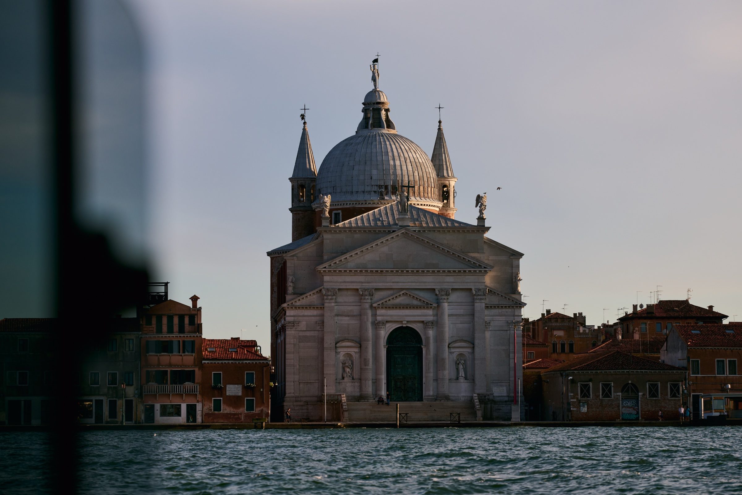 The white façade and dome of Il Redentore across the Giudecca Canal at golden hour, Venice