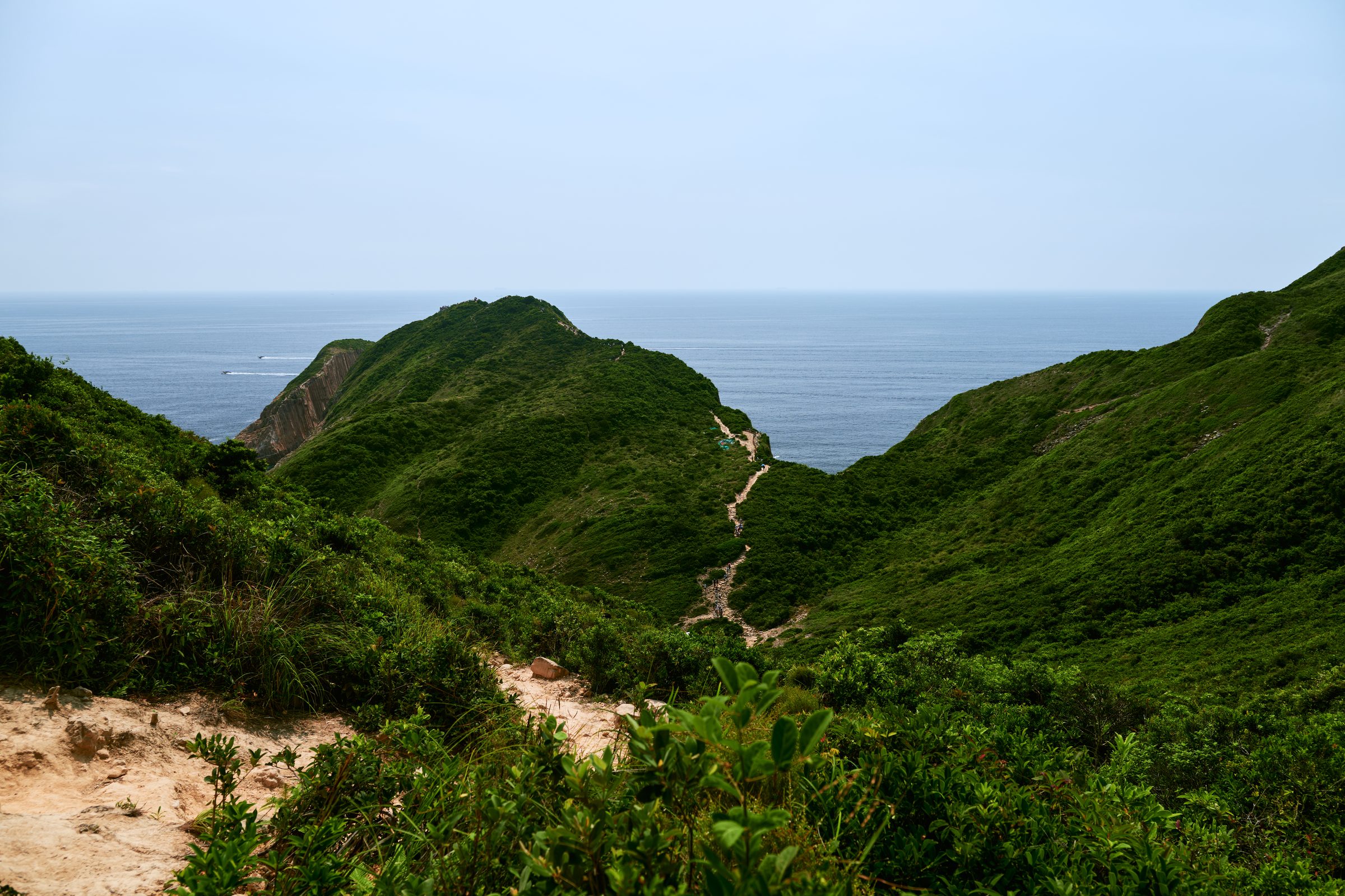 Footpath winding over green ridges toward the sea, MacLehose Trail, Sai Kung, Hong Kong
