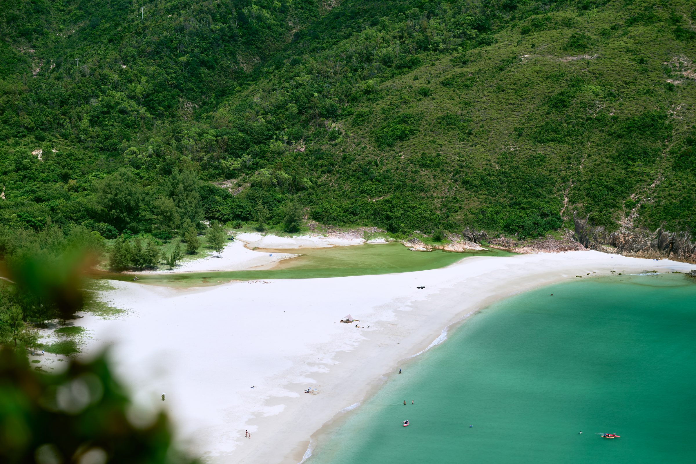 White sand beach, lagoon and turquoise bay below green hills, MacLehose Trail, Sai Kung, Hong Kong