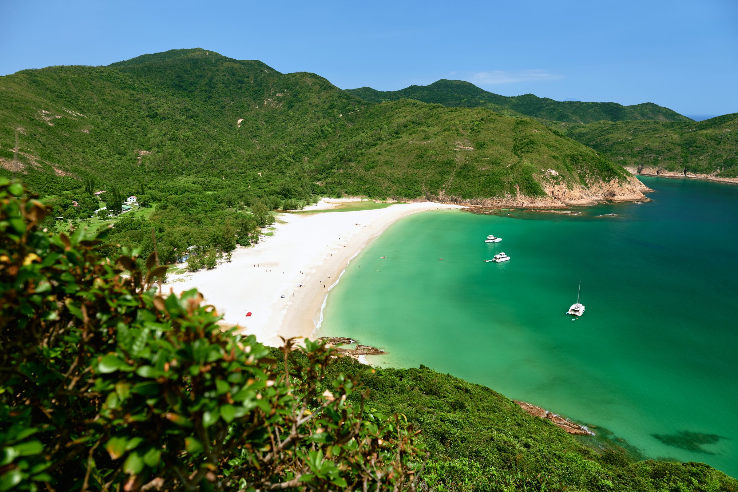 Curving white beach and turquoise bay with moored boats, MacLehose Trail, Sai Kung, Hong Kong