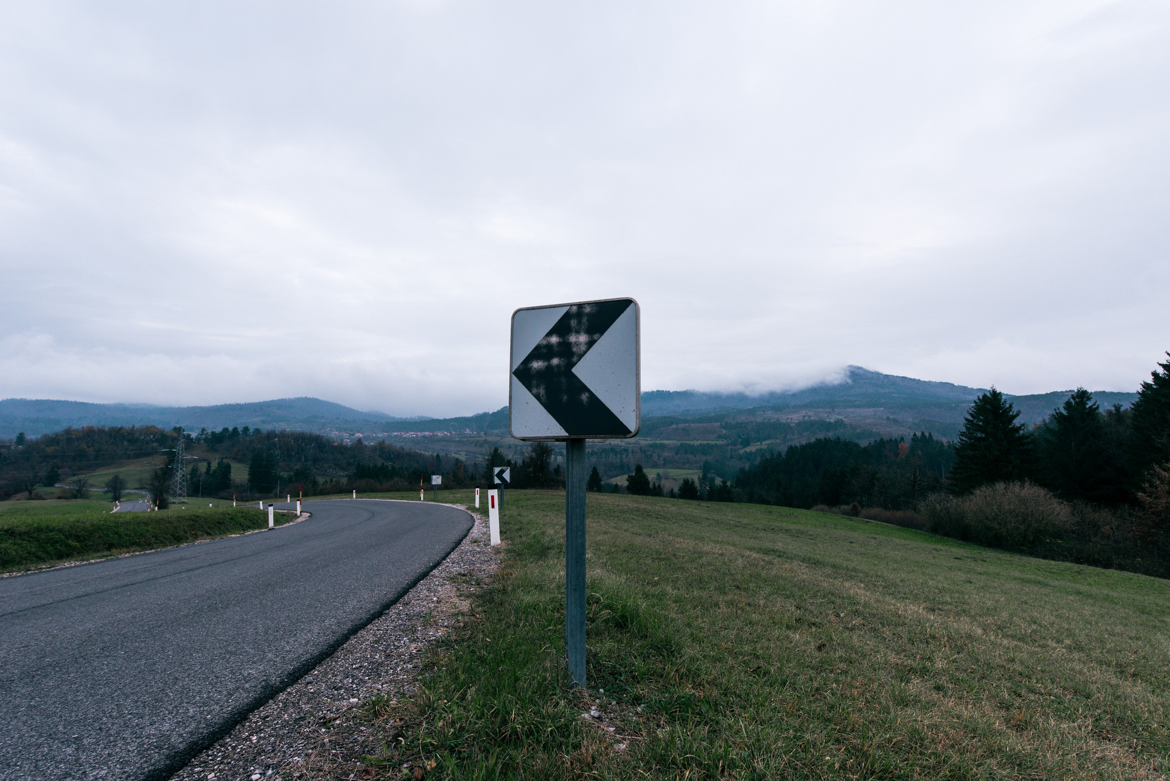 山间弯道路牌与云雾笼罩的群山
