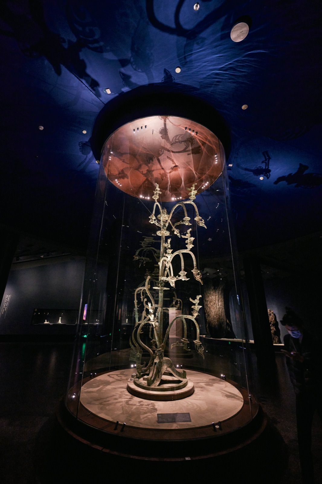 Bronze sacred tree in a glass case against a deep-blue starry wall, Sanxingdui Museum, Guanghan, China