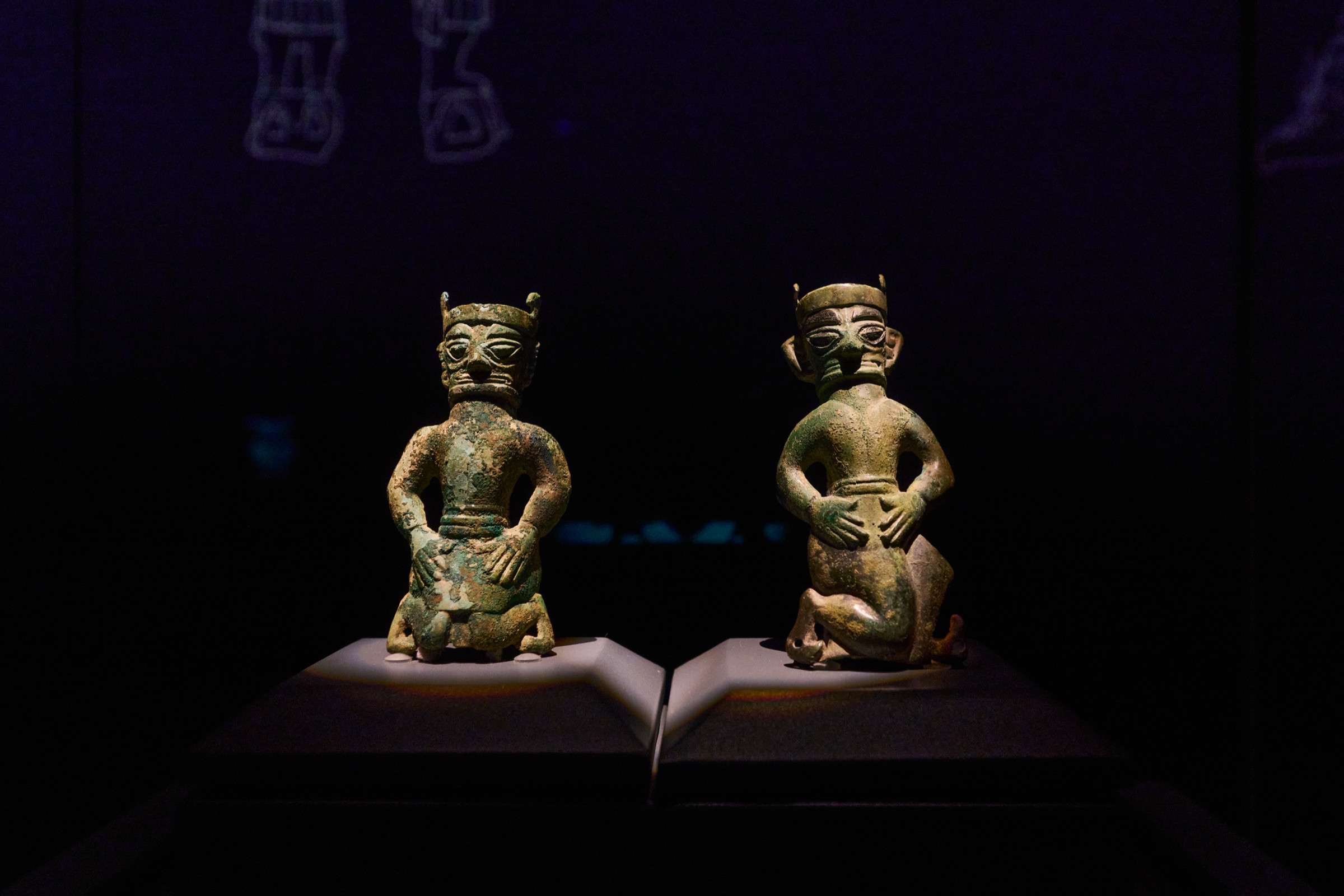 Two small kneeling bronze figures facing each other, Sanxingdui Museum, Guanghan, China